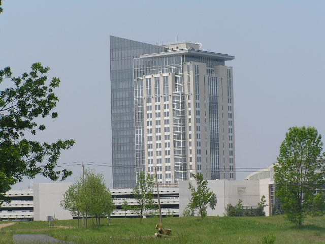 The angular glass-and-stone hotel tower at Turning Stone Resort Casino rising behind trees in upstate New York